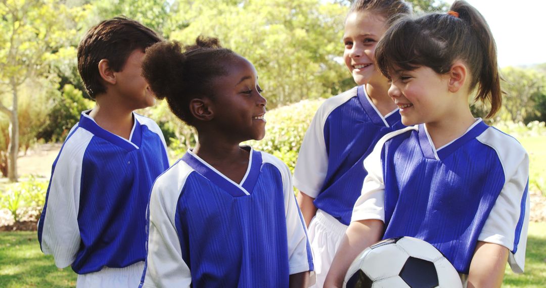 Happy Kids in Soccer Uniforms Interacting Outdoors - Free Images, Stock Photos and Pictures on Pikwizard.com