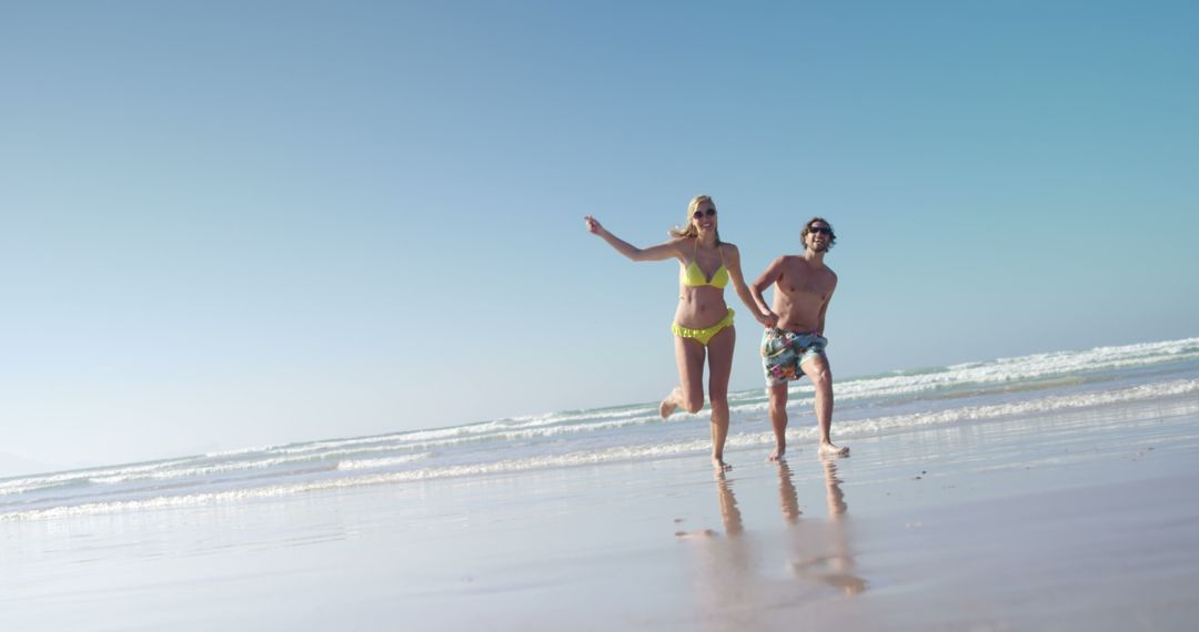 Happy Young Couple Running on Beach at Sunset - Free Images, Stock Photos and Pictures on Pikwizard.com