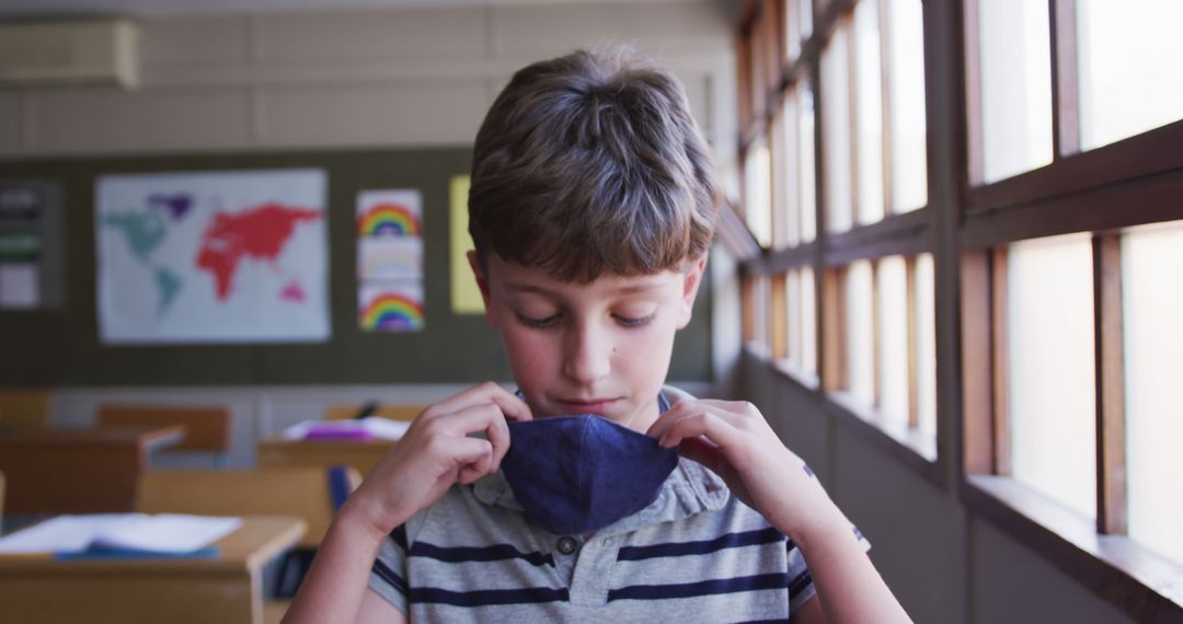 Young Boy Adjusting Face Mask in Classroom Setting - Free Images, Stock Photos and Pictures on Pikwizard.com