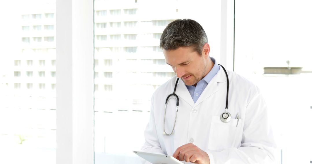 Doctor in White Coat Writing On Tablet In Modern Clinic - Free Images, Stock Photos and Pictures on Pikwizard.com