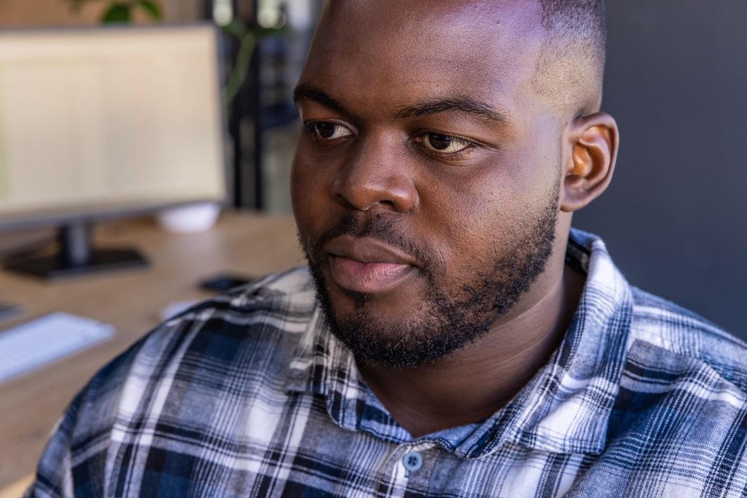 Focused Black Man Working in Modern Workspace with Computer