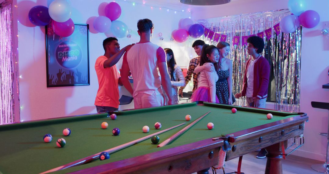 Diverse Friends Celebrating Birthday Party Around Pool Table with Colorful Disco Lights