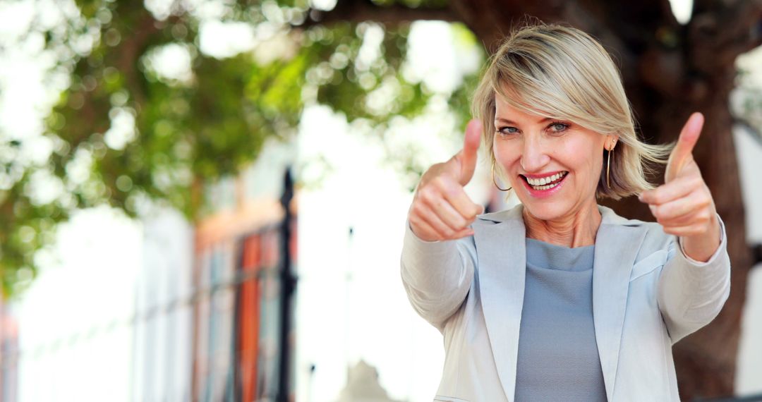 Smiling woman with thumbs up in the city - Free Images, Stock Photos and Pictures on Pikwizard.com