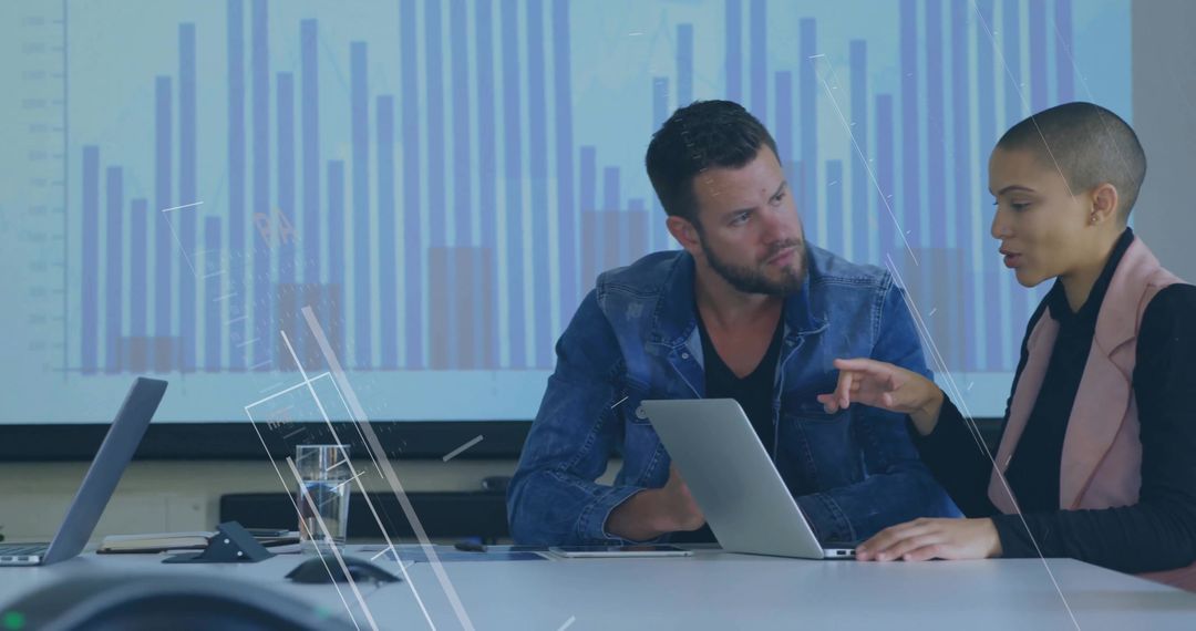 Colleagues Analyzing Data Presentation in Modern Meeting Room