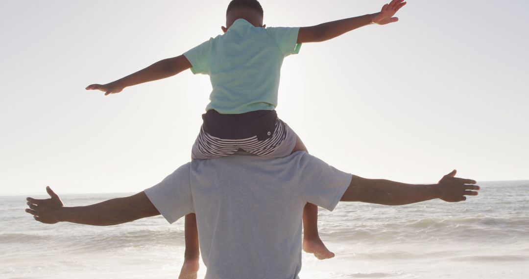 Father Carrying Son on Shoulders at Beach During Sunset - Free Images, Stock Photos and Pictures on Pikwizard.com