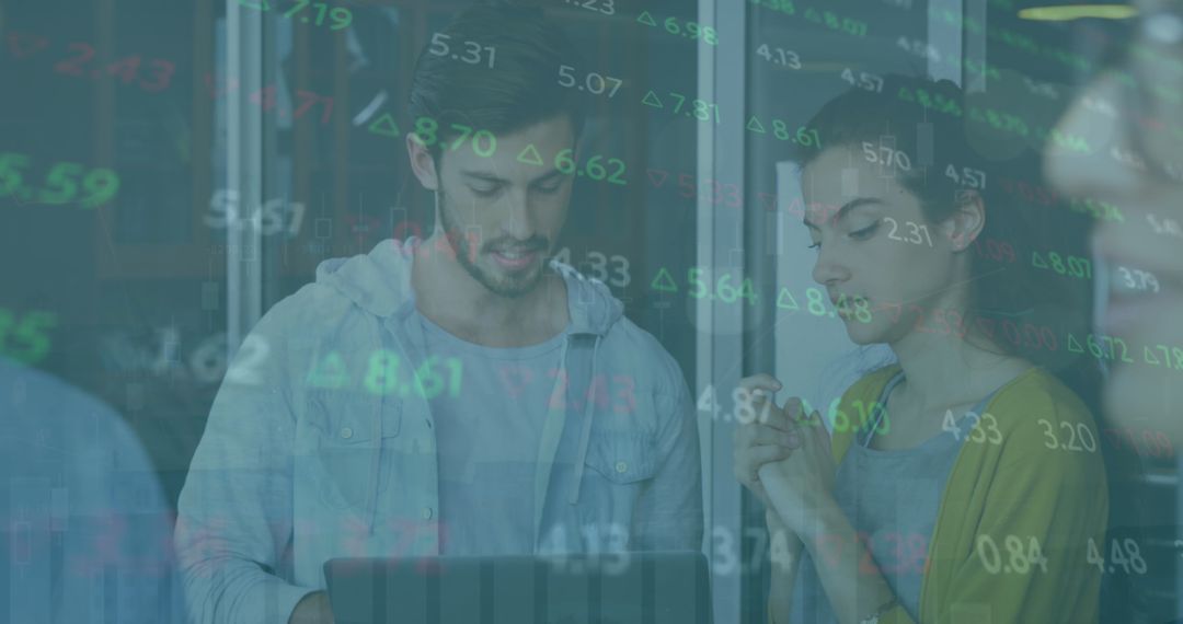 Colleagues Analyzing Stock Market Data Over Laptop Screen