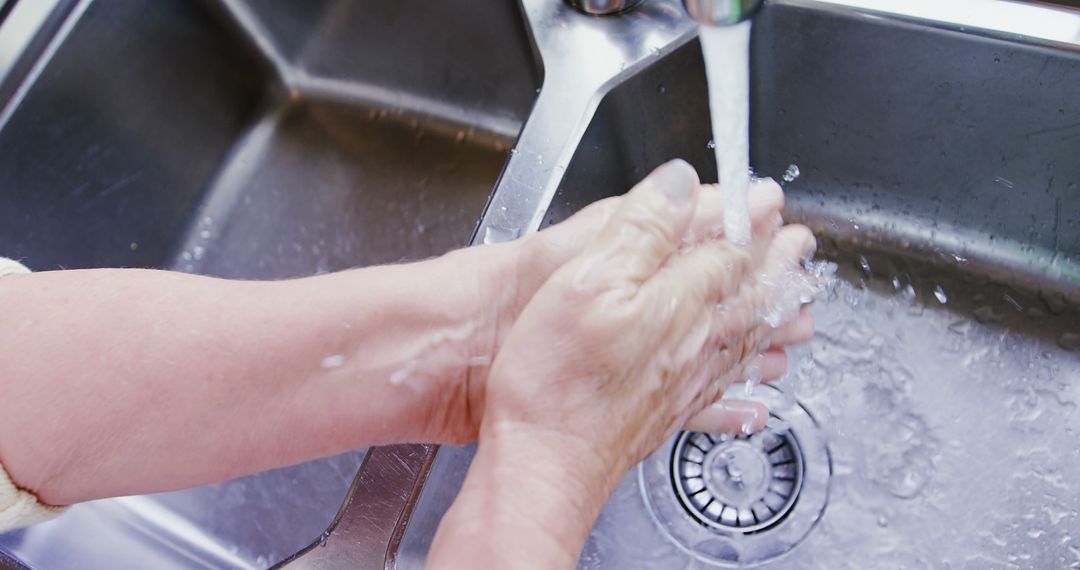 Hands washing under running water at kitchen sink - Free Images, Stock Photos and Pictures on Pikwizard.com