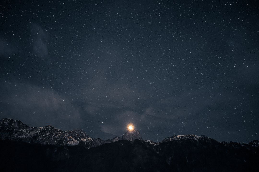 A serene night sky filled with stars above snowy mountain peaks - Free Images, Stock Photos and Pictures on Pikwizard.com