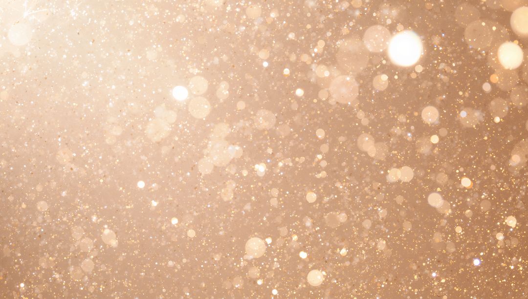 Golden glitter bokeh background with shimmering particles and soft glowing orbs