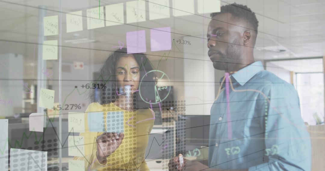 Diverse Team Analyzing Financial Data on Transparent Board in Office