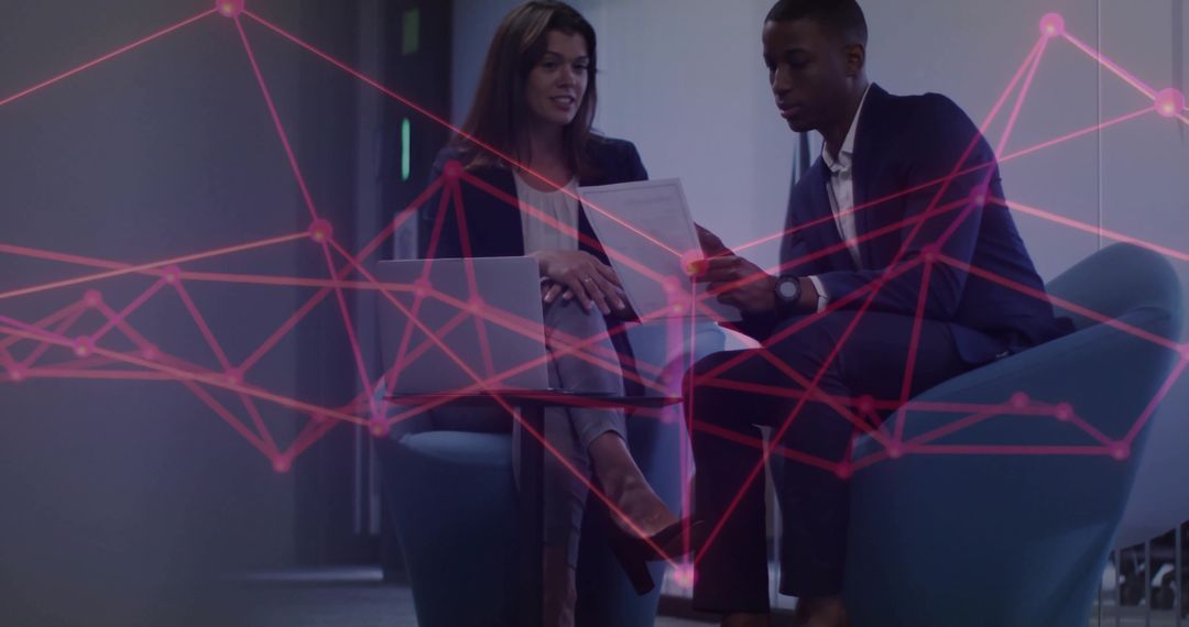 Business Professionals Analyzing Documents in Tech-Inspired Setting