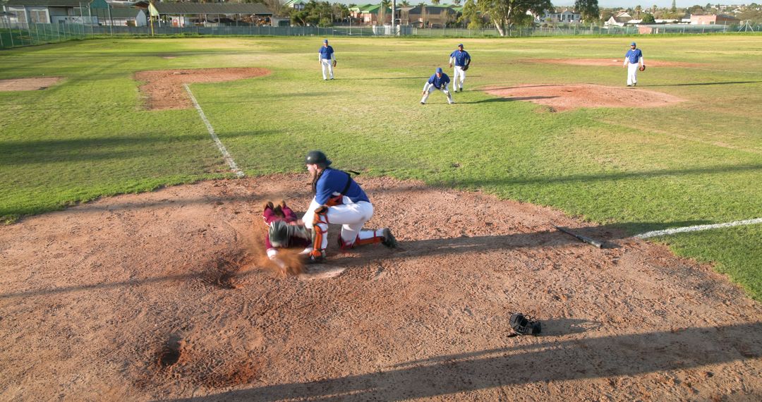 Baseball Players in Action at Home Plate on Sunlit Field