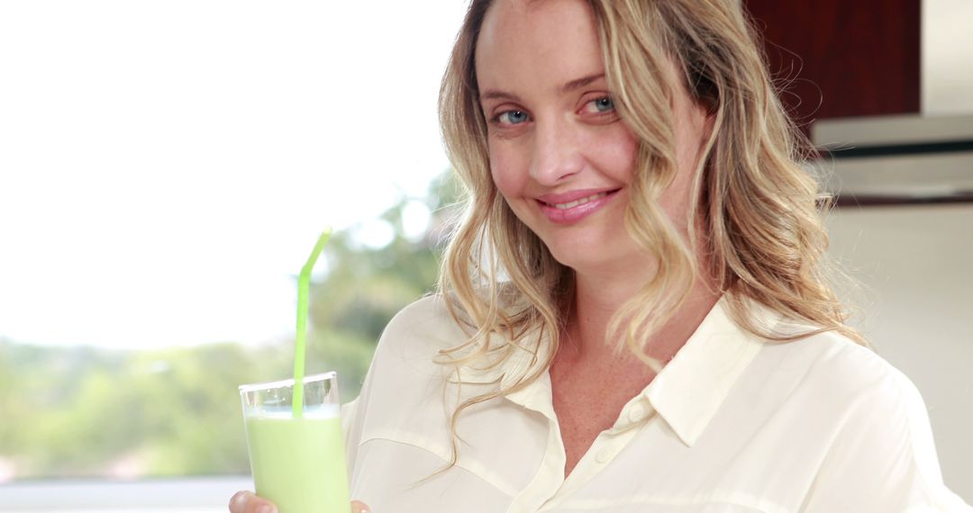 Woman Enjoying Refreshing Green Smoothie in Modern Kitchen - Free Images, Stock Photos and Pictures on Pikwizard.com