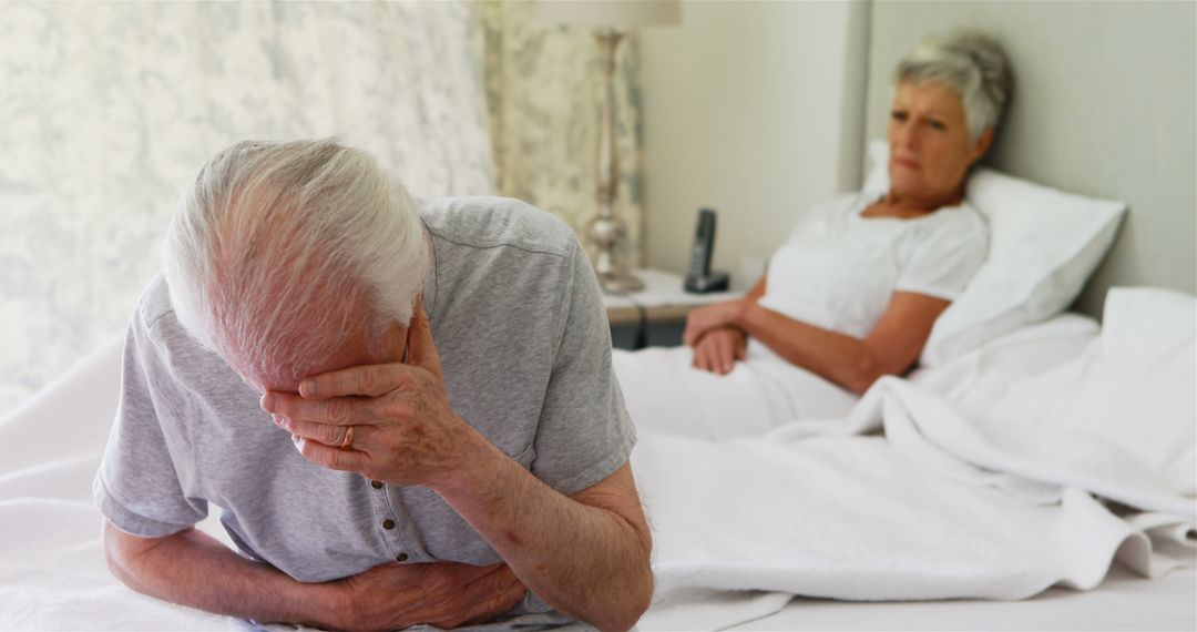 Worried Elderly Couple in Bedroom with Man Experiencing Discomfort - Free Images, Stock Photos and Pictures on Pikwizard.com