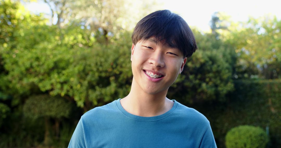 Cheerful Young Man with Braces Smiling Outdoors in Garden