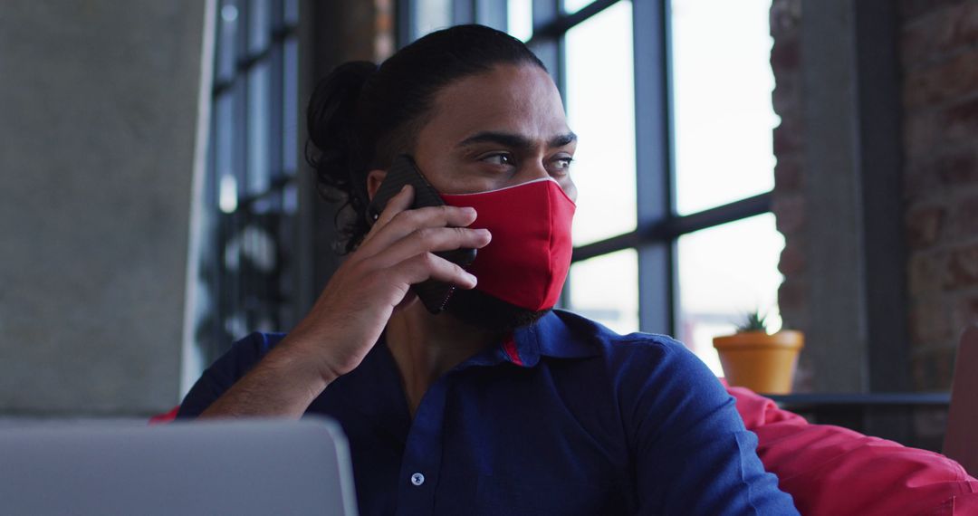 Person in Red Mask Making Phone Call in Modern Office - Free Images, Stock Photos and Pictures on Pikwizard.com