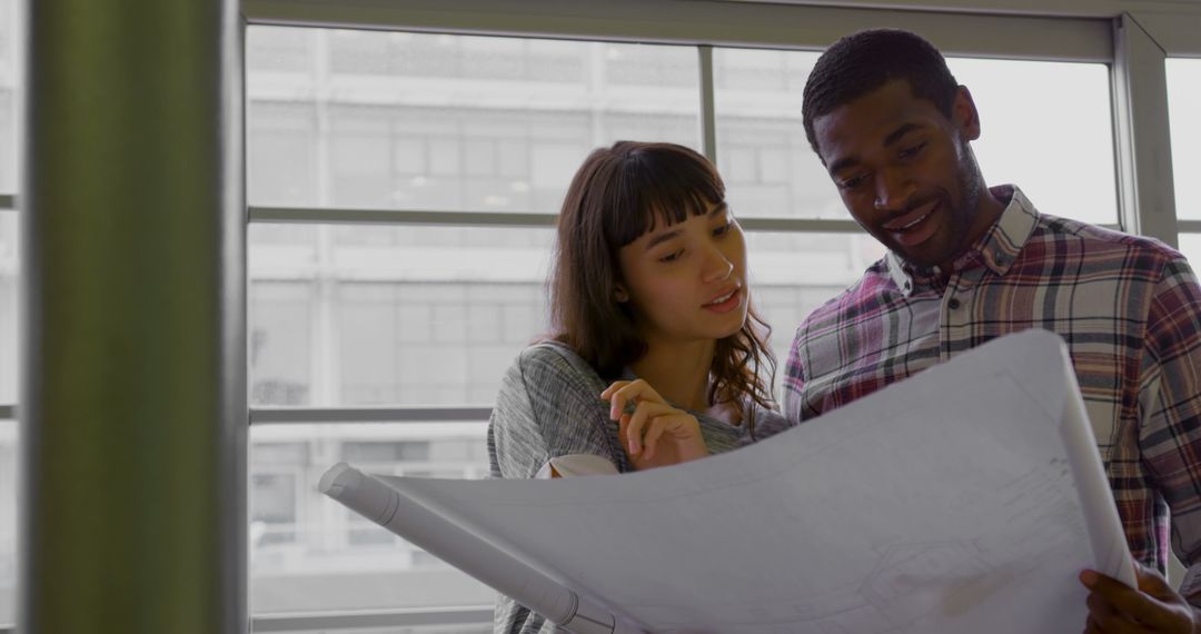 Mixed Ethnicity Colleagues Collaborating on Blueprint Design