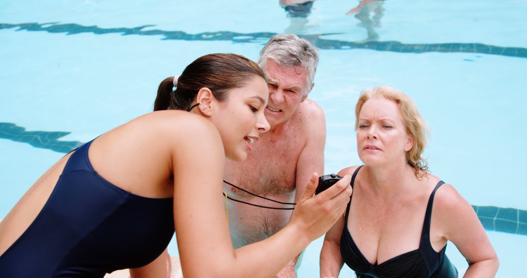 Swim Instructor Timing Elderly Swim Students in Pool - Free Images, Stock Photos and Pictures on Pikwizard.com