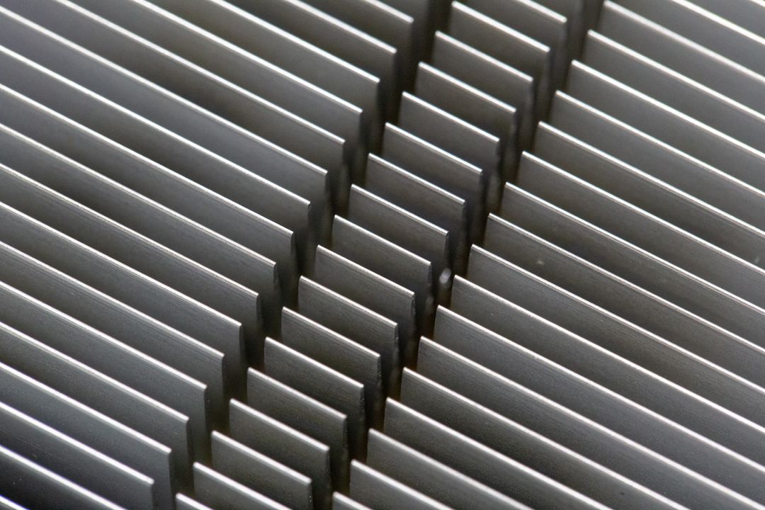 Diagonal aluminum heatsink fins creating repetitive metallic pattern and industrial texture