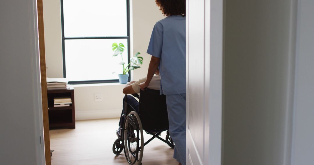 Healthcare Worker Assisting Patient in Wheelchair in Bright Room - Free Images, Stock Photos and Pictures on Pikwizard.com