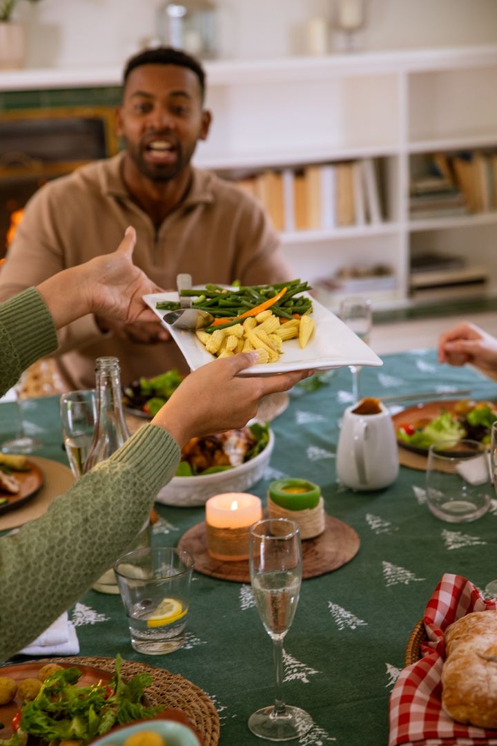 Friendly Gathering Passing Steamed Vegetables at Home Dining Table