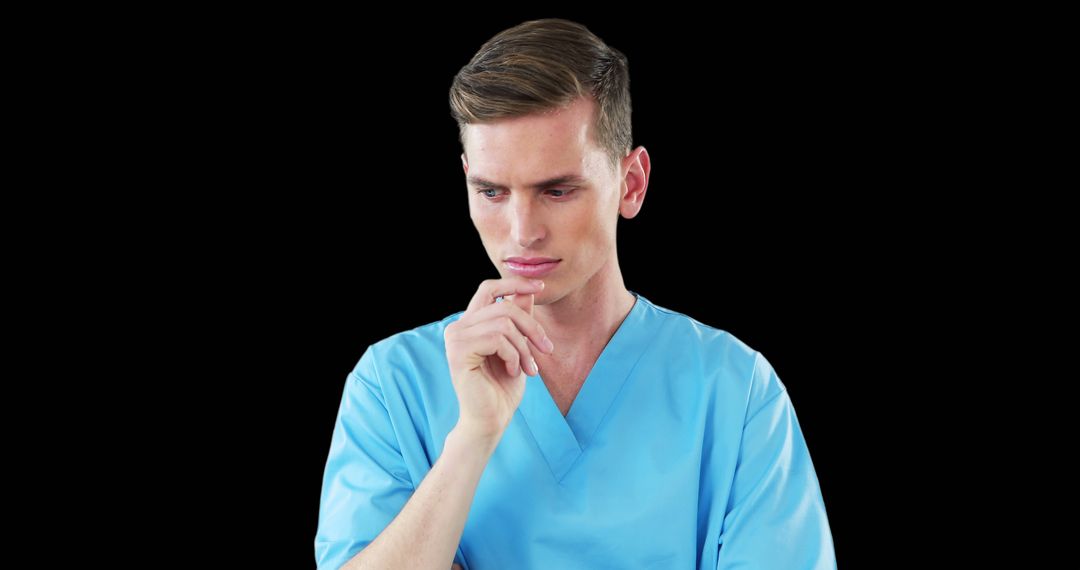 Serious Young Doctor Pondering in Blue Scrubs - Free Images, Stock Photos and Pictures on Pikwizard.com