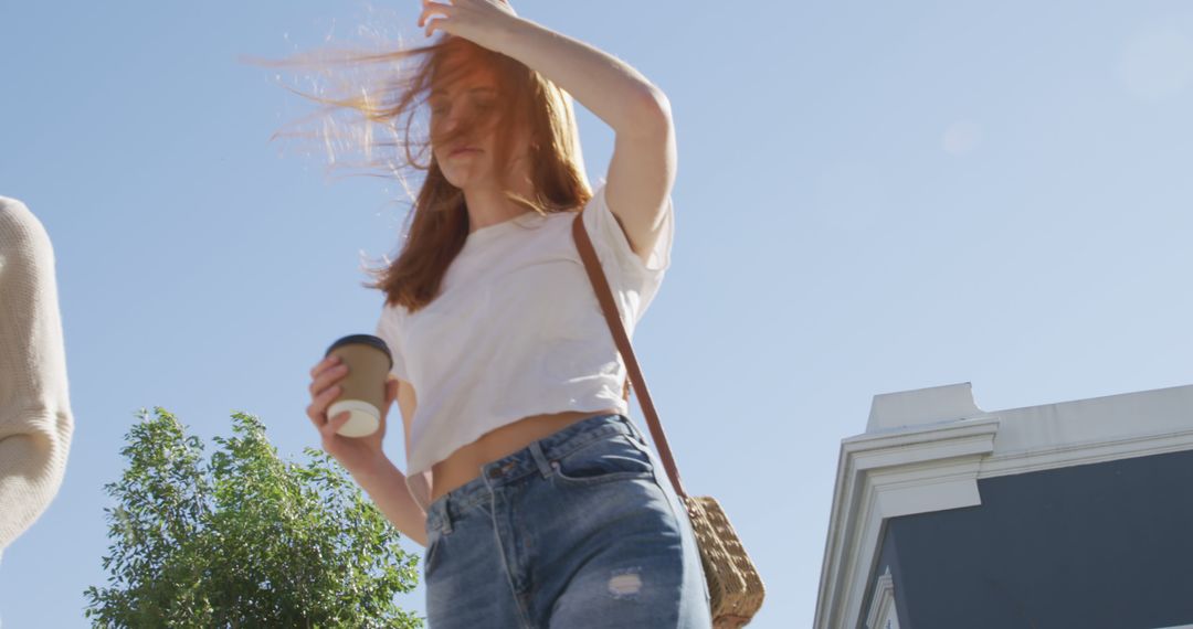 Young Woman Walking with Coffee on a Sunny Day - Free Images, Stock Photos and Pictures on Pikwizard.com