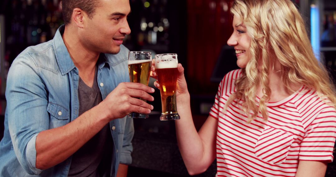 Young Friends Toasting with Beer Glasses at a Bar