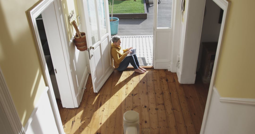 Child Sitting in Sunlit Doorway Reading Book - Free Images, Stock Photos and Pictures on Pikwizard.com