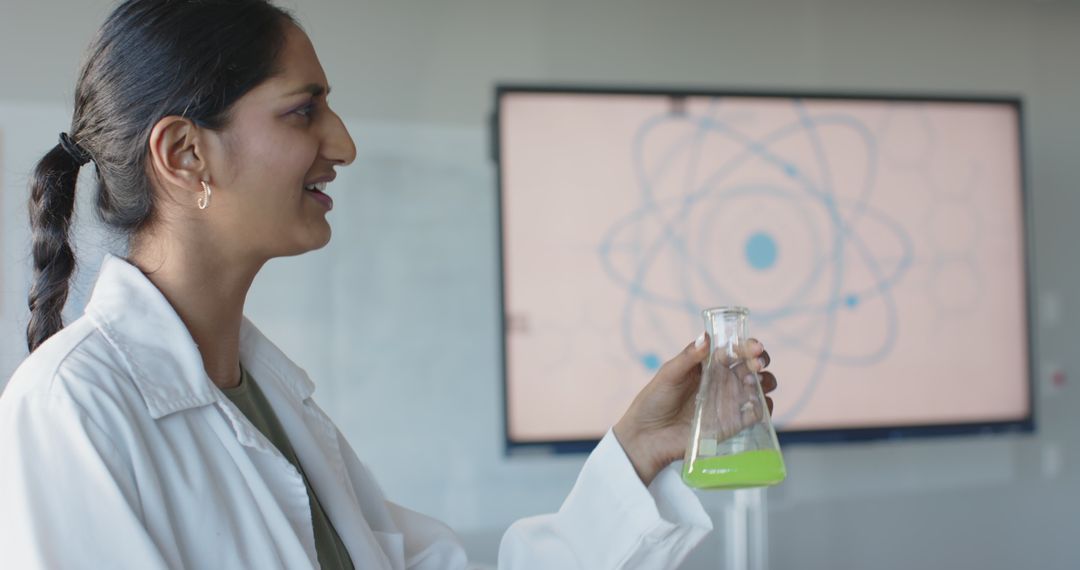 Female Scientist Teaching Chemistry Class with Green Liquid Flask