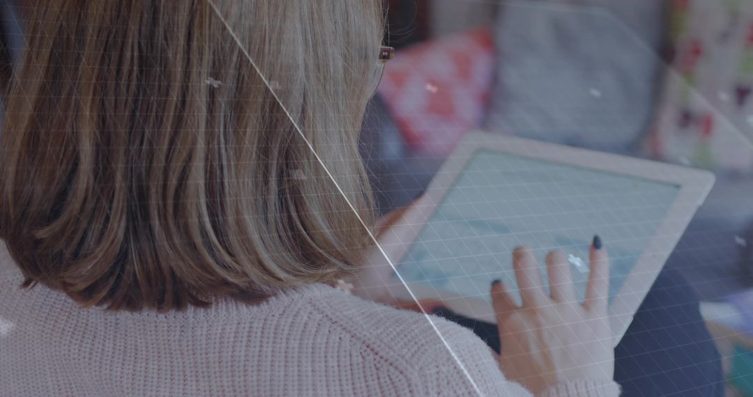 Woman Browsing Tablet Applications in Cozy Home Setting