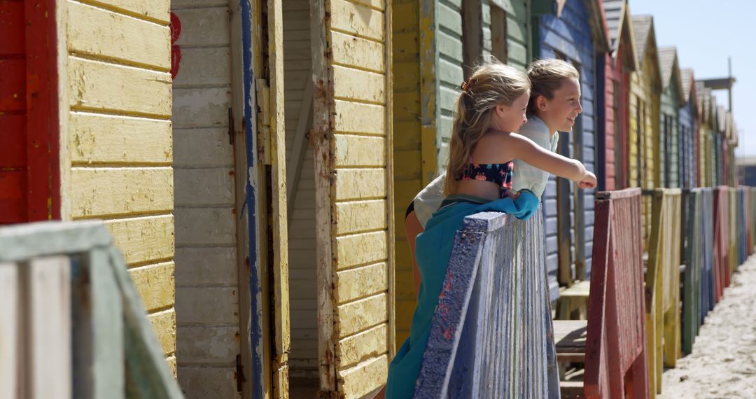 Two Girls Enjoying Summer at Colorful Beach Cabins - Free Images, Stock Photos and Pictures on Pikwizard.com