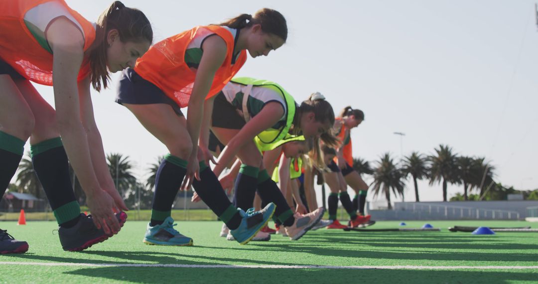 Young Female Athletes Stretching Before Field Hockey Training Outdoors - Free Images, Stock Photos and Pictures on Pikwizard.com