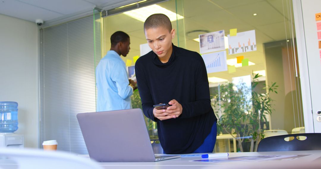 Focused Executive Working on Laptop and Mobile in Contemporary Office
