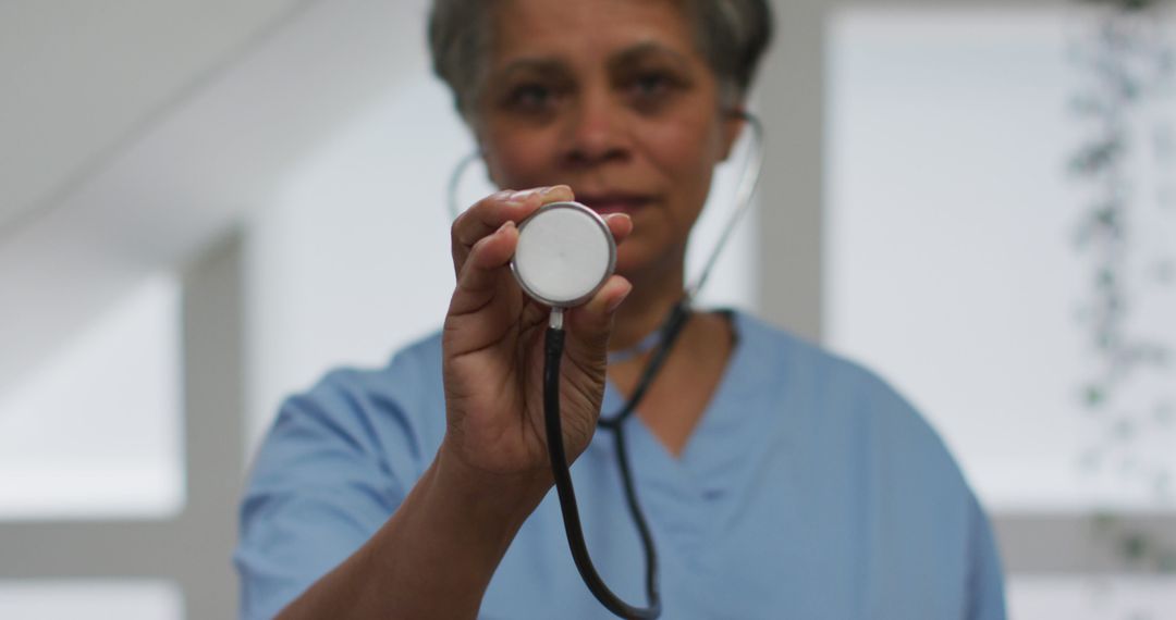 Senior Female Doctor Holding Stethoscope in Medical Office - Free Images, Stock Photos and Pictures on Pikwizard.com