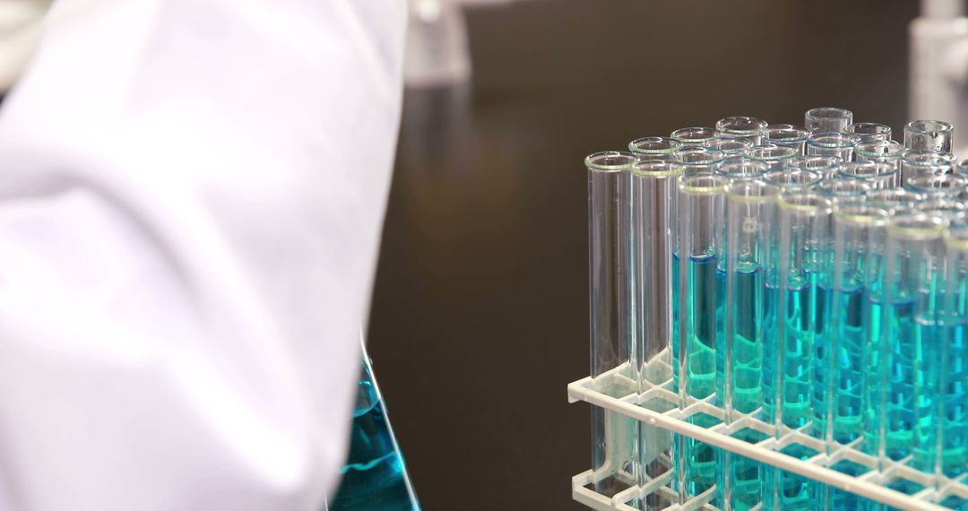 Scientist Conducting Experiment with Blue Liquid in Laboratory Test Tubes - Free Images, Stock Photos and Pictures on Pikwizard.com