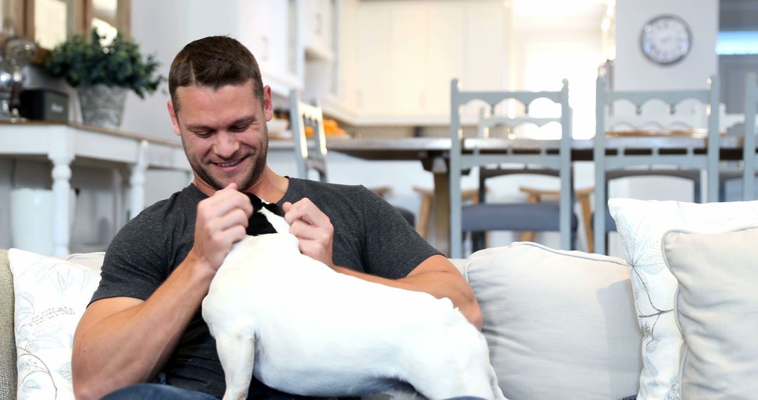 Smiling Man Continuing Enjoyable Time at Home with Pet Dog