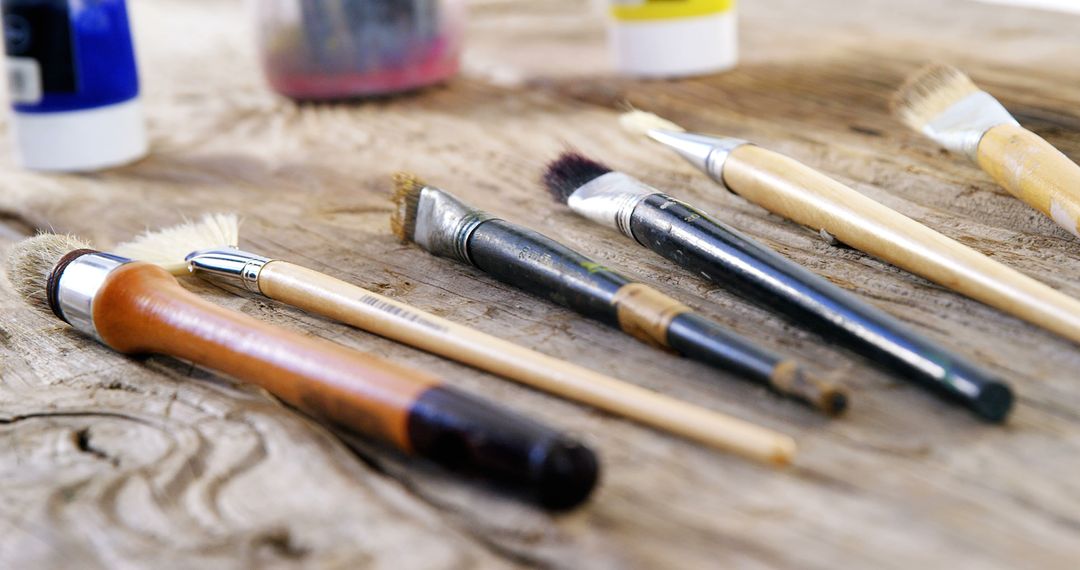 Assortment of paintbrushes on rustic wooden surface in artistic workshop - Free Images, Stock Photos and Pictures on Pikwizard.com