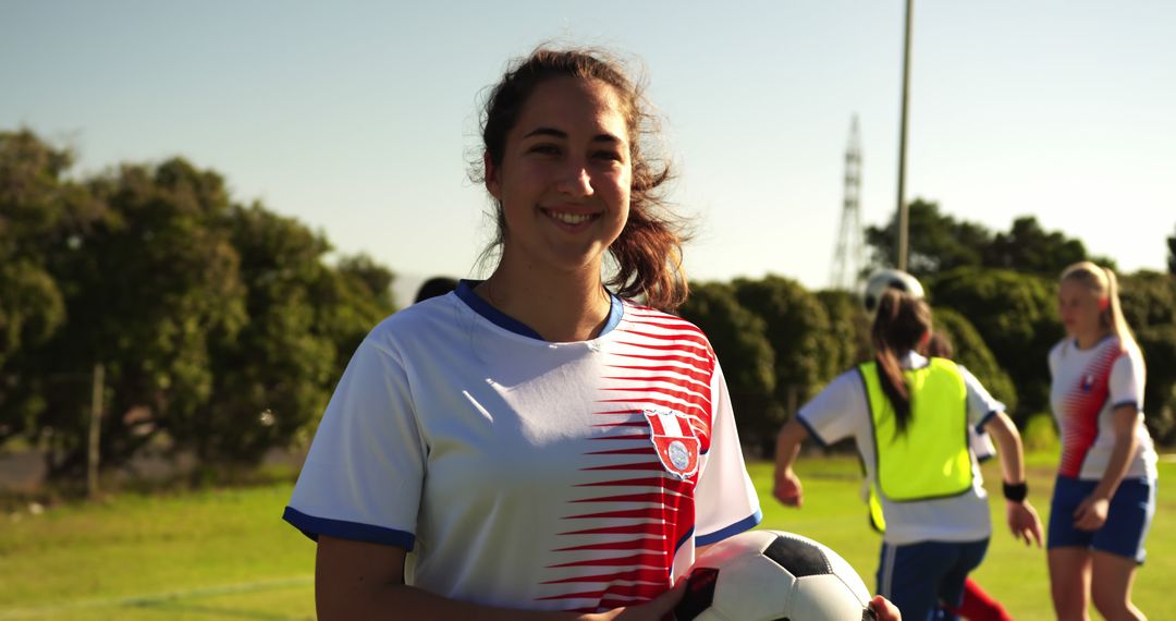 Young Woman Playing Soccer on Field with Teammates in Background - Free Images, Stock Photos and Pictures on Pikwizard.com