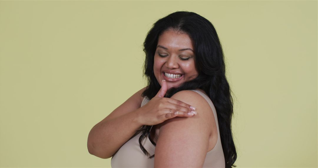Smiling Woman Applying Cream on Shoulder for Skincare Routine