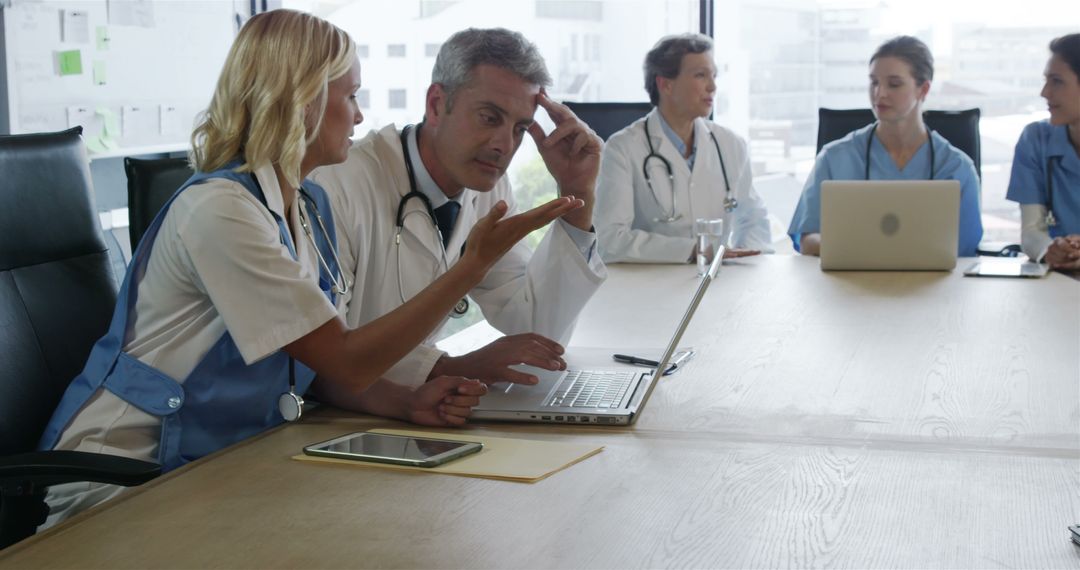 Medical Team in Meeting Discussing Patient Data with Laptop - Free Images, Stock Photos and Pictures on Pikwizard.com