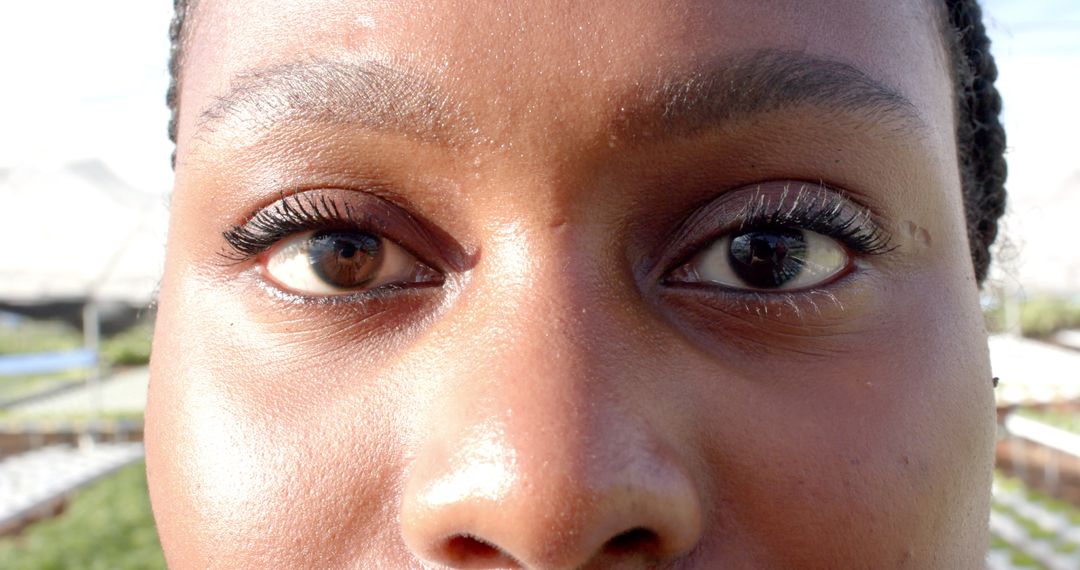 Close-Up of Woman with Inclining Farm View Behind