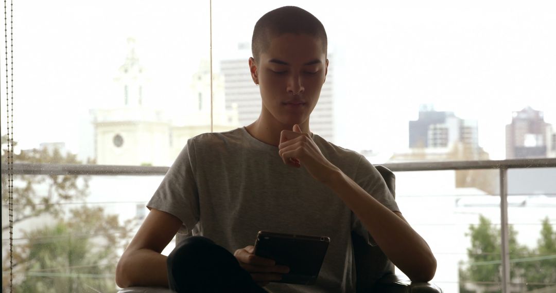 Young Man Using Tablet in Modern Urban Setting with City Background - Free Images, Stock Photos and Pictures on Pikwizard.com