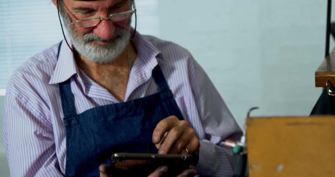 Senior Craftsman Using Digital Tablet in Workshop - Free Images, Stock Photos and Pictures on Pikwizard.com