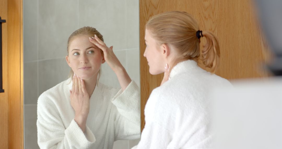 Woman in Bathrobe Practicing Skincare in Minimalist Bathroom