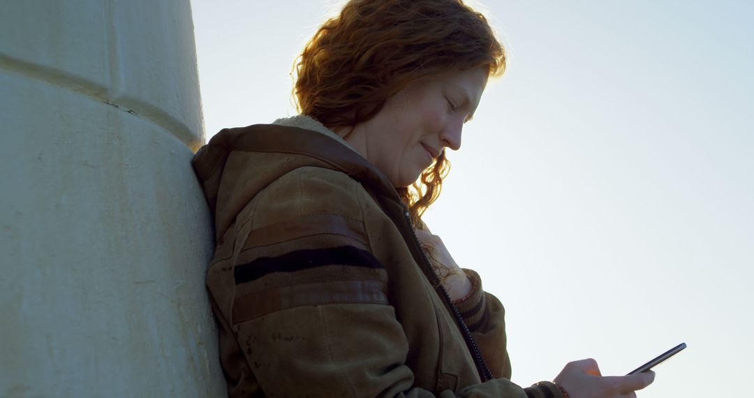 Woman Relaxing with Smartphone Outdoors During Sunset - Free Images, Stock Photos and Pictures on Pikwizard.com