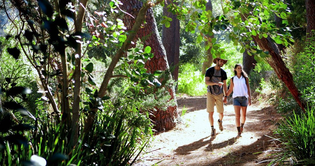 Couple Hiking Through Lush Forest on Sunny Day - Free Images, Stock Photos and Pictures on Pikwizard.com