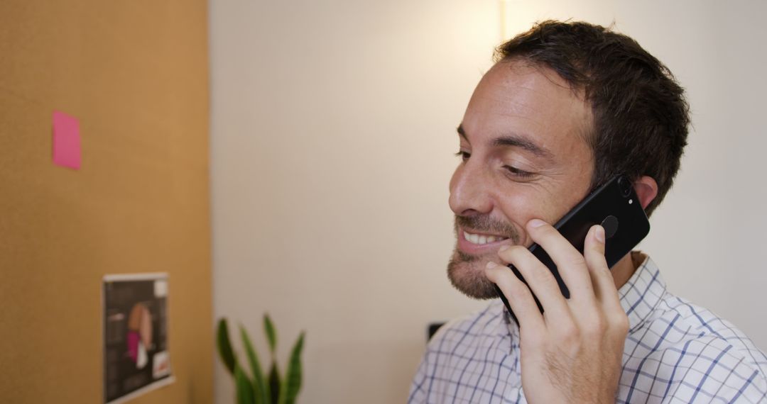 Smiling Man in Office Talking on Smartphone - Free Images, Stock Photos and Pictures on Pikwizard.com