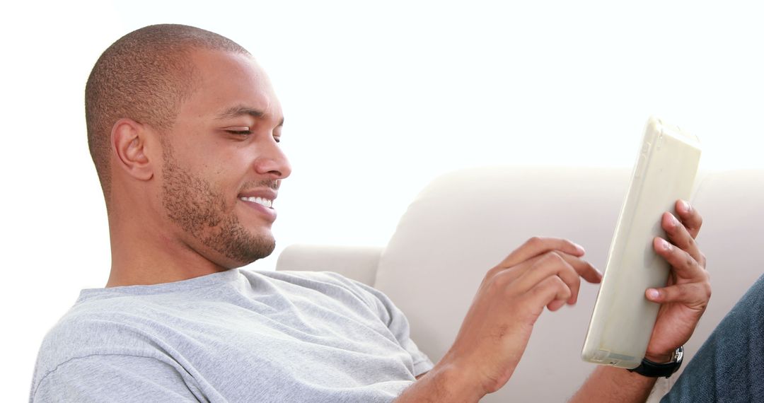 Relaxed Young Man Enjoying Tablet Use at Home