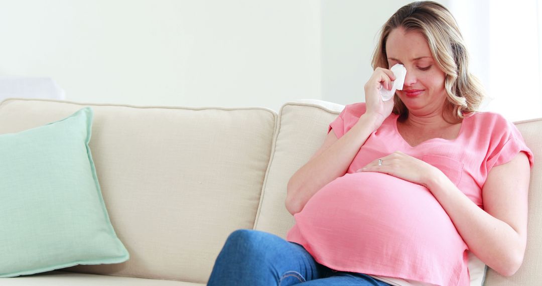 Pregnant Woman Crying on Sofa While Holding Tissue - Free Images, Stock Photos and Pictures on Pikwizard.com